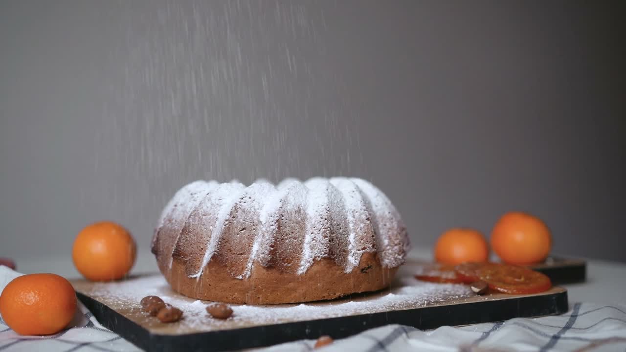 Puderzucker rieselt auf einen frischen Guglhupf